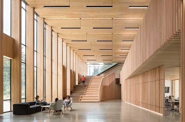 people sitting in a spacious wooden interior with staircase