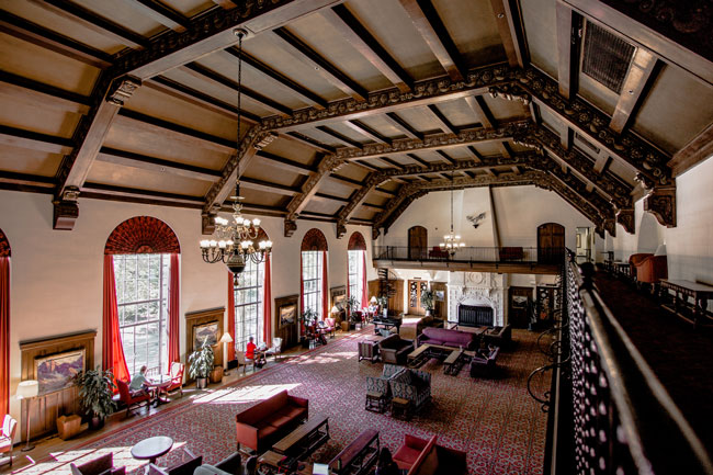 expansive room with couches, large run, and wooden paneling for the ceiling