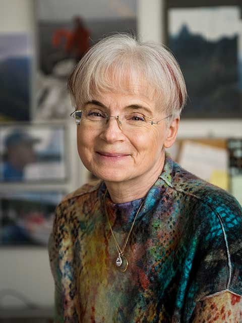 Malgorzata Peszynska smiling while wearing a multicolored shirt, mixed of teals and tans