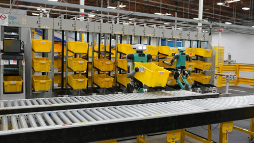 robot picking up yellow bins in a warehouse